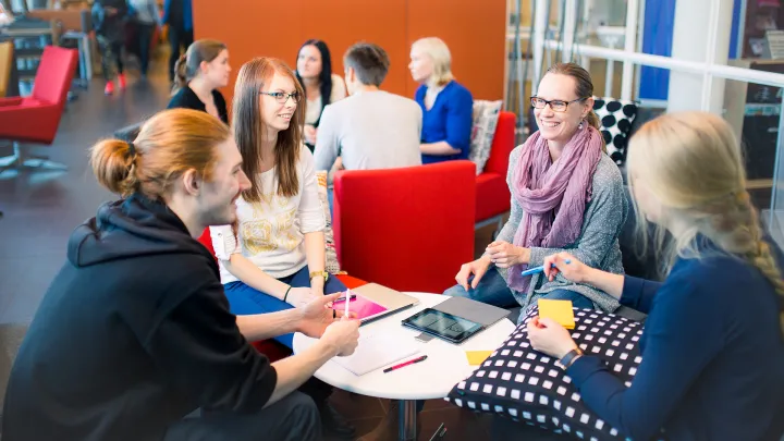 Group of students in library lounge making group work.