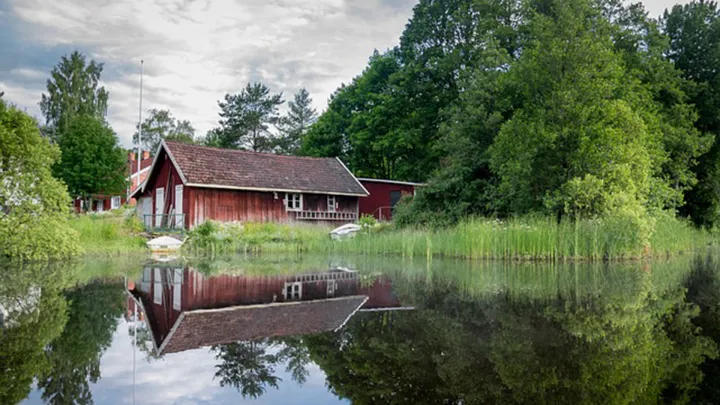 Vanhoja mökkejä veden äärellä