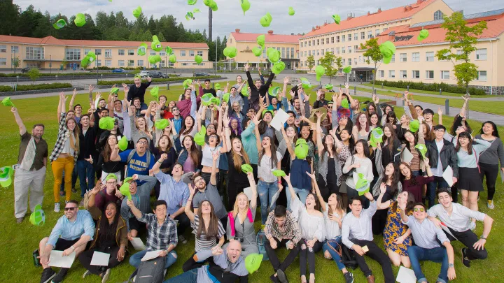 group of happy students throwing their hats in the air